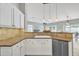 Bright kitchen showcasing white cabinetry, stone backsplash, stainless steel appliances, and an adjacent living area at 2213 E Constance Way, Phoenix, AZ 85042