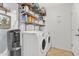Laundry room with a washer and dryer, shelving for storage, and a utility sink at 2213 E Constance Way, Phoenix, AZ 85042