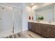Modern bathroom featuring a glass enclosed shower, double sink vanity, and stylish wood-look tile floors at 2942 N 98Th Ln, Phoenix, AZ 85037