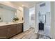 Modern bathroom with double sink vanity, stylish flooring, and a separate toilet room at 2942 N 98Th Ln, Phoenix, AZ 85037