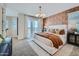 Bright primary bedroom featuring balcony access, patterned accent wall, and neutral decor at 2942 N 98Th Ln, Phoenix, AZ 85037