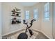 Bright exercise room with wall shelves, bike, yoga ball, and two windows providing natural light at 2942 N 98Th Ln, Phoenix, AZ 85037