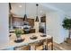 Bright kitchen featuring a breakfast bar with seating, stainless appliances, and stylish pendant lights at 2942 N 98Th Ln, Phoenix, AZ 85037