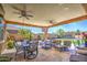 Enjoy a covered patio, complete with ceiling fans, a television, and patio furniture overlooking the expansive backyard at 3016 N Glenview --, Mesa, AZ 85213