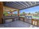 This outdoor kitchen features stone countertops, stainless steel appliances, and a shaded pergola perfect for entertaining at 3016 N Glenview --, Mesa, AZ 85213
