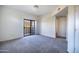 A bright bedroom featuring neutral carpet and a glass sliding door to a private balcony at 3434 E Baseline Rd # 213, Phoenix, AZ 85042