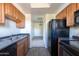 A well-lit kitchen with wood cabinets, sleek appliances, and a view to the living area at 3434 E Baseline Rd # 213, Phoenix, AZ 85042