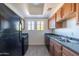 Compact kitchen with wood cabinets, stainless steel sink, and dark countertops at 3434 E Baseline Rd # 213, Phoenix, AZ 85042