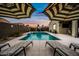 Inviting backyard pool with lounge chairs and umbrellas, perfect for outdoor relaxation and entertaining with a basketball hoop at 37340 W Merced St, Maricopa, AZ 85138