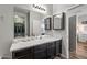 Bathroom featuring a large mirror, vanity with dark wood cabinets, and neutral countertops at 37340 W Merced St, Maricopa, AZ 85138