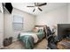 Bedroom with a ceiling fan, bed, and a desk next to a window at 37340 W Merced St, Maricopa, AZ 85138