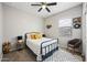 Bedroom featuring a metal bed frame, ceiling fan, and a chair at 37340 W Merced St, Maricopa, AZ 85138