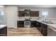 Well-lit kitchen featuring stainless steel appliances, dark cabinetry, and durable floors, maximizing functionality at 37340 W Merced St, Maricopa, AZ 85138