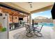 A fully equipped outdoor kitchen and covered patio with a dining table, perfect for al fresco dining near the pool at 37340 W Merced St, Maricopa, AZ 85138