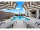 Inviting backyard pool area with lounge chairs, umbrellas, and a basketball hoop for outdoor enjoyment at 37340 W Merced St, Maricopa, AZ 85138