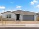 Charming single-story home with a gray exterior, a gray tiled roof, and a brick driveway at 4029 S 176Th Dr, Goodyear, AZ 85338