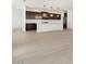 Modern open-concept kitchen featuring dark wood cabinets, a white island, and an adjacent living area at 4029 S 176Th Dr, Goodyear, AZ 85338