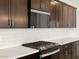 Close-up of kitchen featuring stainless steel range, quartz countertops, and dark cabinets at 4029 S 176Th Dr, Goodyear, AZ 85338