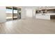 Open-concept living space with wood-look flooring, a sliding door to the backyard, and a glimpse of the kitchen at 4029 S 176Th Dr, Goodyear, AZ 85338