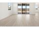Bright living space with wood-look flooring, natural light, and sliding glass doors to the backyard at 4029 S 176Th Dr, Goodyear, AZ 85338