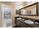 Bathroom featuring double sinks, granite countertop, and a shower at 4628 E Gelding Dr, Phoenix, AZ 85032