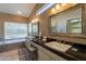 Bathroom featuring dual sinks, granite countertops, tub and a large window with lots of light at 4628 E Gelding Dr, Phoenix, AZ 85032