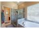 Bright bathroom featuring a glass-enclosed shower and luxurious soaking tub at 4628 E Gelding Dr, Phoenix, AZ 85032