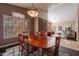 Dining room features a wood table and a large window for natural light, adjacent to the living room at 4628 E Gelding Dr, Phoenix, AZ 85032