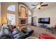 Open-concept living room with a fireplace, large windows, comfortable seating, and modern entertainment setup at 4628 E Gelding Dr, Phoenix, AZ 85032