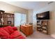 Home office featuring a cozy red couch, desk, and built-in shelving at 4628 E Gelding Dr, Phoenix, AZ 85032