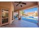 Inviting covered patio, ceiling fan, and view of the pool offer an ideal outdoor space for entertaining and relaxation at 4628 E Gelding Dr, Phoenix, AZ 85032