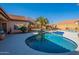 Sparkling pool with blue tile and a curved design offers a refreshing oasis in the backyard with well-maintained desert landscape at 4628 E Gelding Dr, Phoenix, AZ 85032