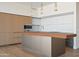 Island kitchen boasts wooden and white cabinets, stainless appliances, and wood floors at 5000 N Camelback Ridge Dr # 203, Scottsdale, AZ 85251