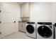 Functional laundry room with washer, dryer, storage cabinets, and utility sink at 5000 N Camelback Ridge Dr # 203, Scottsdale, AZ 85251