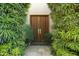 Inviting front entrance with double wooden doors and lush, mature landscaping at 5642 N Scottsdale Rd, Paradise Valley, AZ 85253