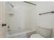 Bathroom featuring a tub and shower combination with white tiling, and a toilet at 6885 E Cochise Rd # 219, Paradise Valley, AZ 85253