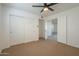 Bedroom with a ceiling fan, closet, and entryway leading to another room with laminate flooring at 6885 E Cochise Rd # 219, Paradise Valley, AZ 85253