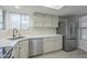 Sunlit kitchen with stainless steel appliances and white cabinets features a window and laminate flooring at 6885 E Cochise Rd # 219, Paradise Valley, AZ 85253