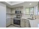 Bright kitchen features stainless appliances, white countertops and backsplash, window, and neutral-toned cabinets at 6885 E Cochise Rd # 219, Paradise Valley, AZ 85253