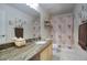 Well-lit bathroom with a granite countertop and patterned shower curtain at 7511 E Desert Vista Rd, Scottsdale, AZ 85255