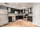 A well-lit kitchen with modern black cabinetry and stainless steel appliances with hardwood flooring at 7920 E Camelback Rd # 408, Scottsdale, AZ 85251