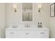 Close-up of a modern vanity with white countertop, stylish faucet, decorative items, and sconces flanking a mirror at 7982 W Griswold Rd, Peoria, AZ 85345