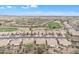 Expansive aerial view of a vast desert community adjacent to a verdant golf course, under a clear blue sky at 8096 E Lavender Dr, Gold Canyon, AZ 85118