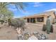 A view of the backyard showing the covered patio and well-maintained desert landscaping at 8096 E Lavender Dr, Gold Canyon, AZ 85118
