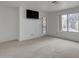 Bright living room features neutral carpet, a mounted TV, and a glass door to the outside at 8096 E Lavender Dr, Gold Canyon, AZ 85118