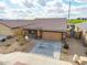 An aerial front view of a well-maintained home with a desert landscape, attached two car garage, and a tile roof at 8552 S 258Th Dr, Buckeye, AZ 85326