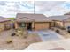 Aerial view of a single story house with a tile roof, desert landscaping, and a two car garage at 8552 S 258Th Dr, Buckeye, AZ 85326