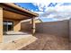 Exterior view of the outdoor patio with an adjacent brick wall and sliding glass door at 8552 S 258Th Dr, Buckeye, AZ 85326