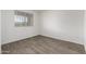 Clean and bright bedroom with wood-look flooring, neutral paint, and a large window at 8552 S 258Th Dr, Buckeye, AZ 85326