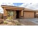 Inviting home exterior with stone accents, covered porch, and a low maintenance desert landscape at 8552 S 258Th Dr, Buckeye, AZ 85326